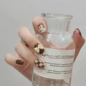 Brown checkerboard press-on nails with 3D cream bow and chocolate melt design