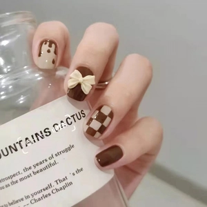 Checkerboard press-on nails with 3D bows and chocolate drip design in round shape