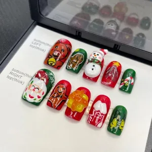 Handmade 3D Christmas press-on nails with Santa and reindeer art on a white tray