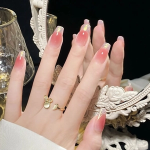 Detail of pink gradient press-on nails with gold foil and rabbit opal ring