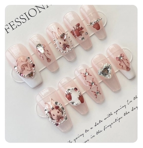 Detail of handmade press-on nails with 3D rabbit, strawberry, and crystal heart charms