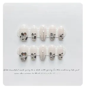 Detail of pink gradient coffin press-on nails with 3D silver hearts and glitter