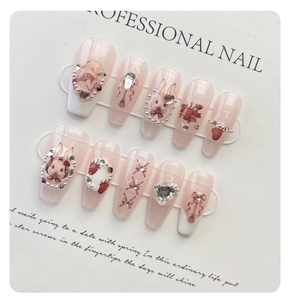 Detail of handmade press-on nails featuring vintage rabbit and strawberry art motifs