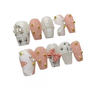Ongles faits main rose et crème avec perles, nœuds et motifs de texture en tweed