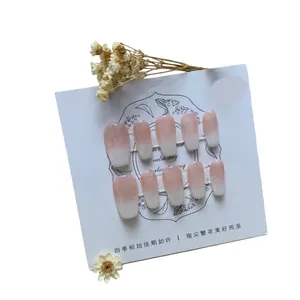Pink and white gradient medium ballerina press-on nails set on a floral display card