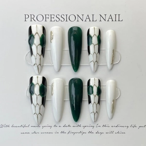 Green and white stiletto press-on nails with snake print pattern and silver accents