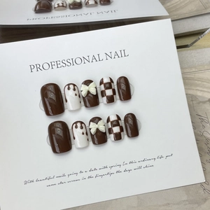 Handmade brown checkerboard press-on nails with chocolate drip and white 3D bows
