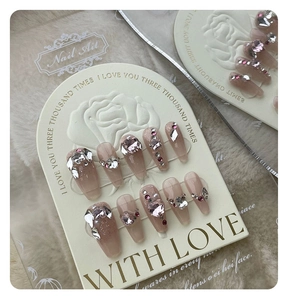 Macro detail of handmade press-on nails with luxury rhinestones and pink heart crystals