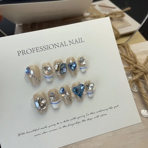Handmade French press-on nails set with blue crystals and heart diamond designs