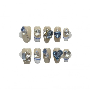 Handmade press-on nails with blue hearts and rhinestones in a French tip style