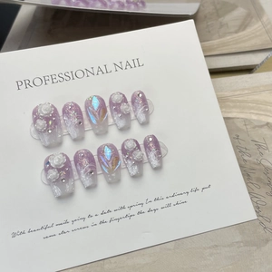 Detail of purple gradient press-on nails with 3D white roses and sparkling rhinestones