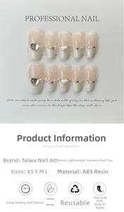 Dettaglio di unghie finte French nude con cuori 3D, strass e perle per manicure elegante