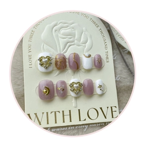 Detail of handmade press-on nails with 3D heart pearls and leopard print on embossed card