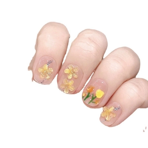 Handmade press-on nails with 3D yellow tulip designs and sparkling glitter on nude base