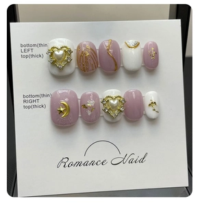 Detailed view of handmade pink leopard press-on nails with gold hearts and pearls