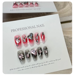 Détail de faux ongles dégradés avec strass coeur 3D, papillons en métal et fleurs en relief