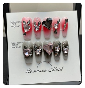 Détail de faux ongles 3D faits main avec breloques cœur et dégradés floraux sur carte