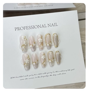 Detailed macro view of 3D flower and pearl decorations on pink cat-eye press-on nails