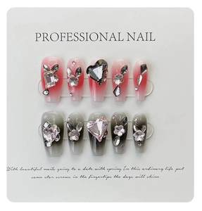 Détail de faux ongles cercueil longs avec dégradé et strass en forme de cœur et cristaux