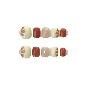 Handmade press-on toenails in brick red and cream with floral art and gold foil