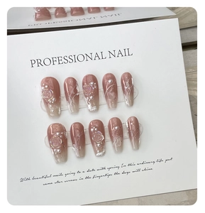 Detail of pink gradient coffin press-on nails with 3D floral accents and pearls