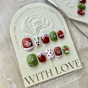 Faux ongles de Noël faits main avec renne et bonhomme de neige en rouge et vert festifs