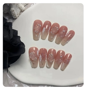 Detail of handmade ombré press-on nails with 3D embossed roses and pearl accents