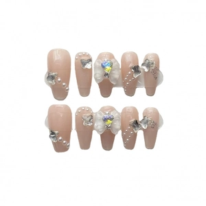 Handgemaakte kunstnagels in nude roze met parels en zilveren vlinderbedeltjes