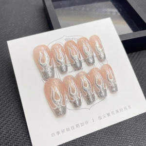 Handmade press-on nails featuring nude pink base with silver glitter flame designs