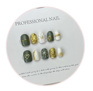Detail of handmade 3D embossed nail tips with floral patterns and gold metallic textures