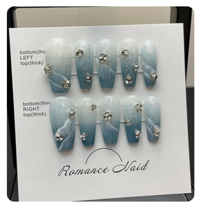 Macro view of blue ocean marble press-on nails with 3D rhinestones and silver glitter