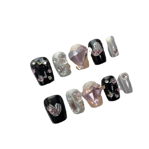 Y2K style handmade press-on nails in black and pink with large heart-shaped rhinestones