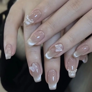 Vue détaillée d'ongles cercueil avec pointes œil de chat argentées, perles et papillon 3D
