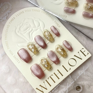 Detailed view of hand-painted cat eye press-on nails with golden floral accents