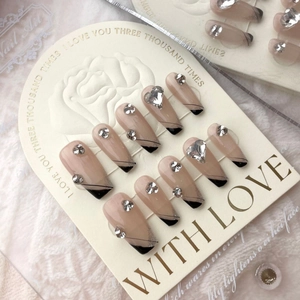 Faux ongles faits main French noire avec paillettes argentées et cristaux en cœur