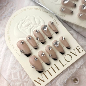 Faux ongles press-on coffin noirs style French avec strass brillants en cœur