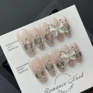 Faux ongles faits main rose clair avec paillettes argentées papillon et diamants