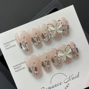 Faux ongles faits main dégradé rose avec paillettes argentées, strass et motifs papillon