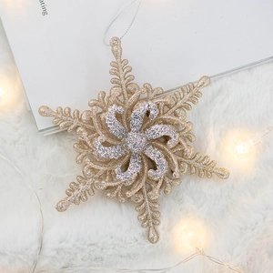 Sparkling snowflake Christmas ornaments with gold and silver glitter on white plush background