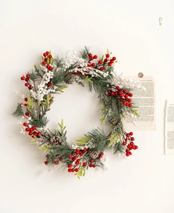 Detailed Christmas wreath with pine needles, red berries, and natural cones on a wall