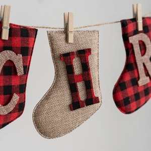 Christmas buffalo plaid and burlap stocking banner with wooden clips on jute rope