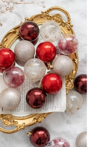 Close-up of assorted 6cm red and gold Christmas balls on a decorative tray