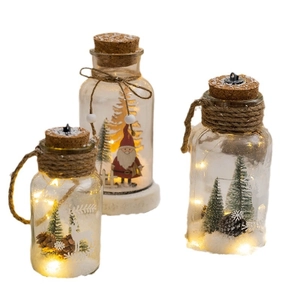 Three glowing glass Christmas lanterns with LED lights, pine cones, and Santa Claus figures