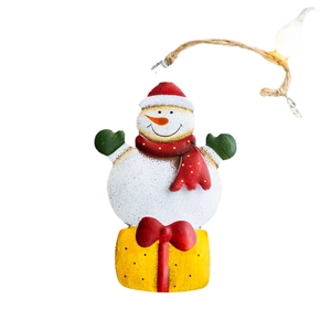 Christmas snowman metal ornament with red hat and gift box hanging on a jute rope