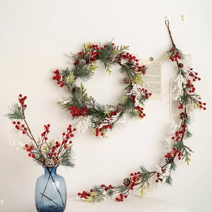 Christmas wreath and red berry garland set with pine cones on a white wall decoration