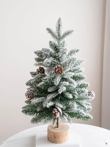 Mini tabletop flocked Christmas tree with snow needles and natural pine cones on wood base