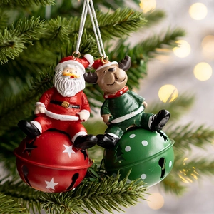 Christmas tree ornaments with Santa and reindeer on festive bells hanging on a branch
