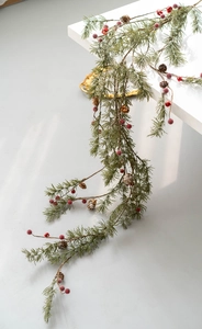 Close-up of Christmas garland with pine needles, red berries, and natural pinecones