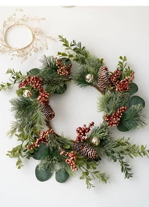 Christmas wreath detail with pine needles, red berries, pine cones and gold bells