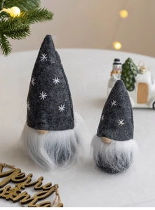 Detail of grey Christmas gnomes with star embroidery and white beards in a cozy setting